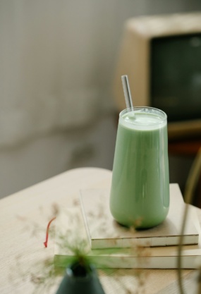 Smoothie vert healthy avec paille, sur table en bois, style minimaliste, ambiance naturelle, promotion nutrition saine, concept de bien-être.
