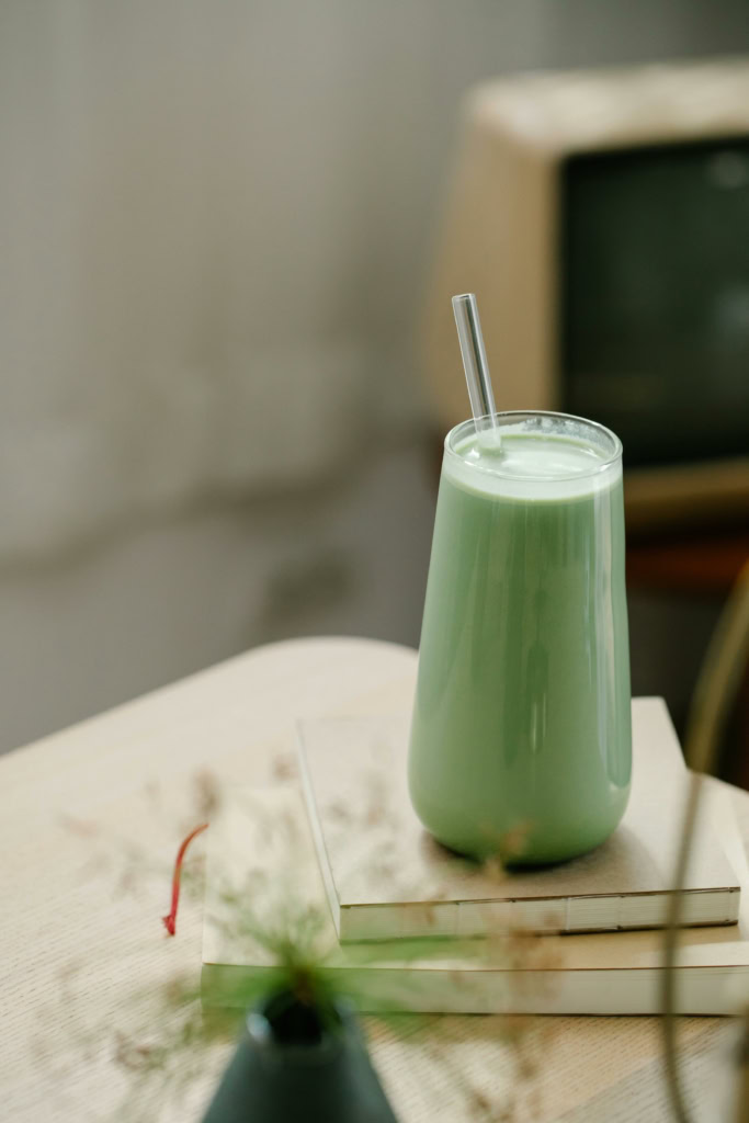 Smoothie vert healthy avec paille, sur table en bois, style minimaliste, ambiance naturelle, promotion nutrition saine, concept de bien-être.