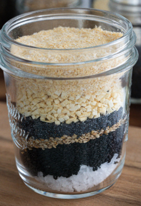 Paillettes de graines de chia, sésame, pâte de noix, sel dans un bocal en verre.