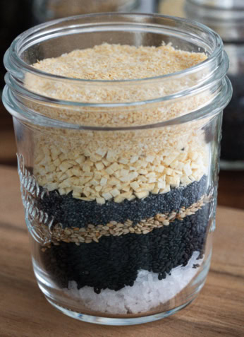 Paillettes de graines de chia, sésame, pâte de noix, sel dans un bocal en verre.