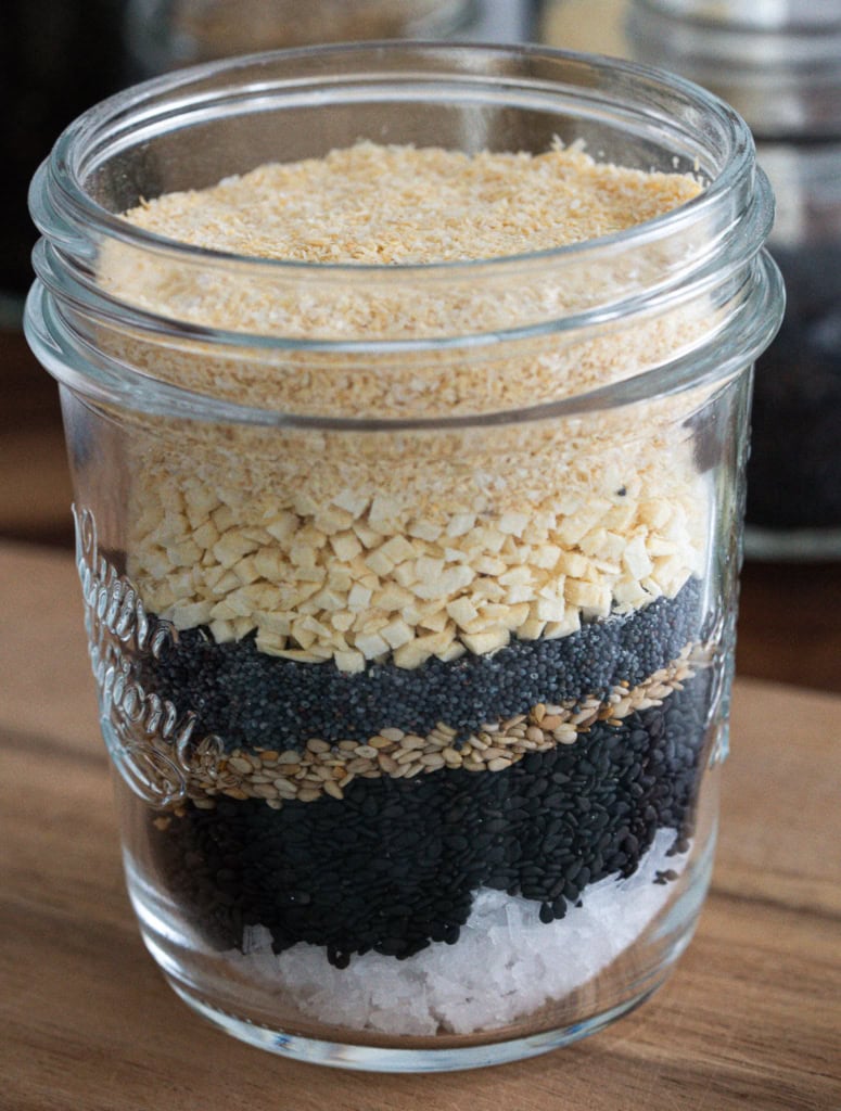 Paillettes de graines de chia, sésame, pâte de noix, sel dans un bocal en verre.
