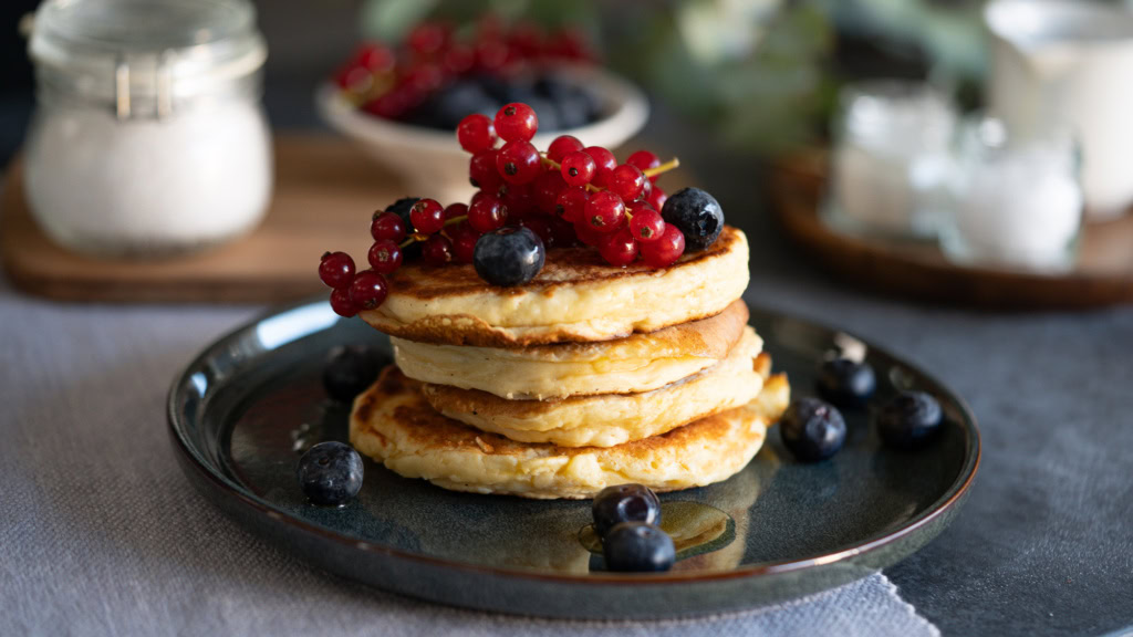 Délicieux pancakes aux fruits rouges frais et myrtilles, parfaits pour une alimentation saine et équilibrée, idéal pour un petit déjeuner nutritif.