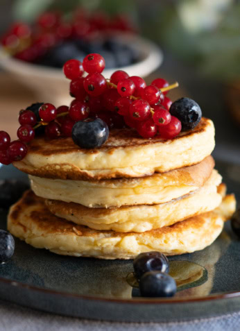 Délicieux pancakes aux fruits rouges frais et myrtilles, parfaits pour une alimentation saine et équilibrée, idéal pour un petit déjeuner nutritif.