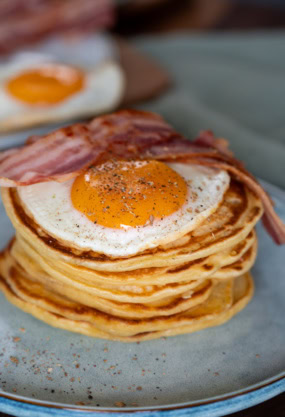 Oeufs au plat sur pancakes, avec bacon, petits déjeuners riches en protéines et saveurs gourmandes, idéale pour un petit déjeuner équilibré.