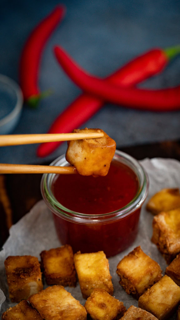 Fritures de tofu croustillant avec sauce tomate, accompagnées de piments rouges frais, mettant en valeur une alimentation saine et savoureuse pour une nutrition équilibrée.