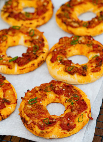 Bagels à la viande hachée et aux épices garnis de ciboulette, cuits au four, aliments sains pour une alimentation équilibrée.